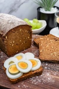 Richtig dunkles Schwarzbrot als Vollkornbrot Rezept mit Roggenschrot und Rübenkraut oder Zuckerrübensirup. Dunkles Brot, das an Pumpernickel Brot erinnert und etwas mehr Zeit durch Quell und Backphasen benötigt, ohne kompliziert zu sein.